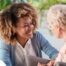 A caregiver warmly speaks with an older client, representing the quality communication that can come with bilingual care.