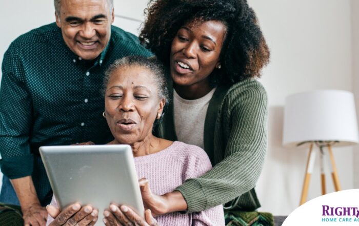 A daughter looks at a tablet with her older parents, representing technology and how ti can help with aging in place.