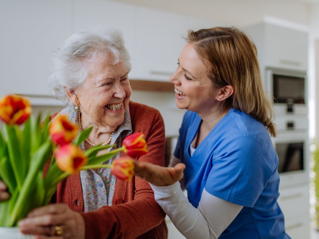 Home Care in Langhorne, PA Caregiver smiling and talking with an elderly woman receiving home care in Langhorne, PA